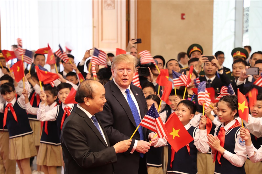 Tổng thống Donald Trump vẫy cờ cùng học sinh.
